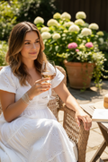 Girl in summer dress wearing silver bangles with glass of wine outside